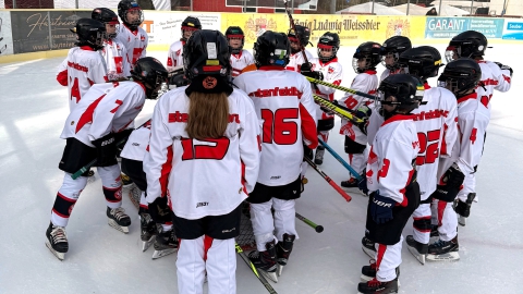 Spieler der U9 des EVF versammeln sich im Eisstadion der Amperoase um ihr Tor.